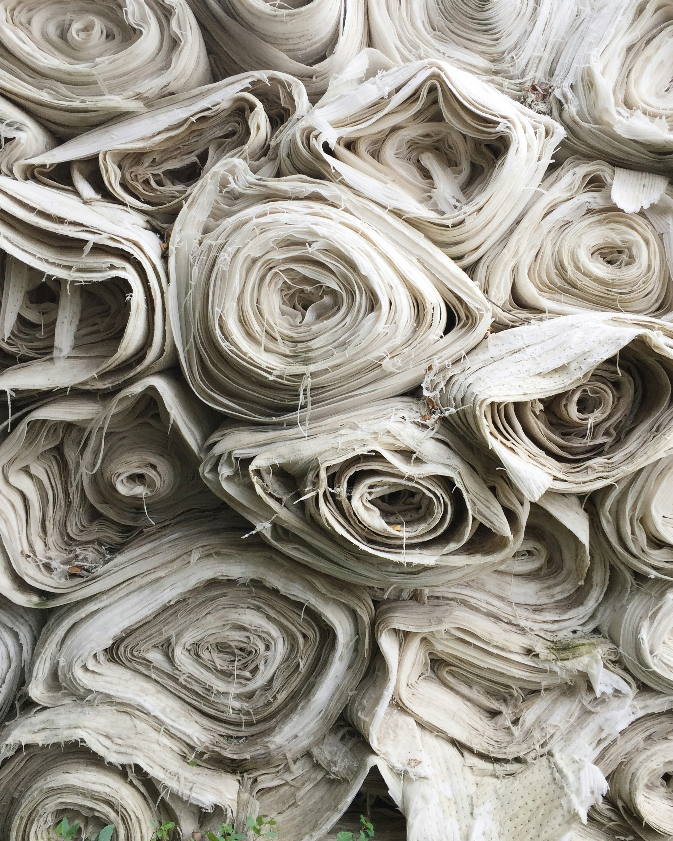 Rolls of fabric stacked atop each other.